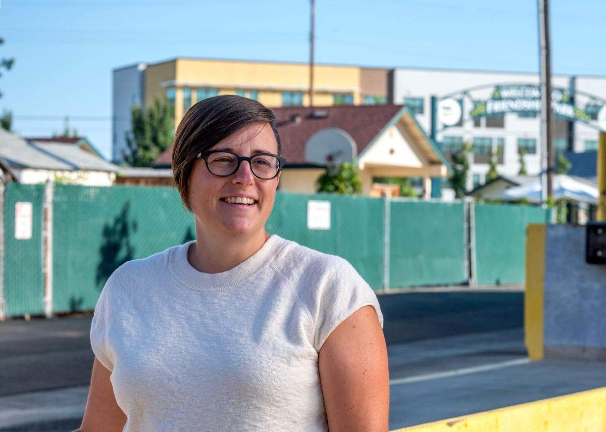 Angela Hassell, executive director of homeless services provider Loaves & Fishes, stands Monday on the grounds of her organization near Friendship Park in Sacramento’s River District as the new Mirasol Village housing complex rises in the distance. “I would say we are good neighbors to the community around us and obviously most importantly to the folks experiencing homelessness that are near us,” she said.