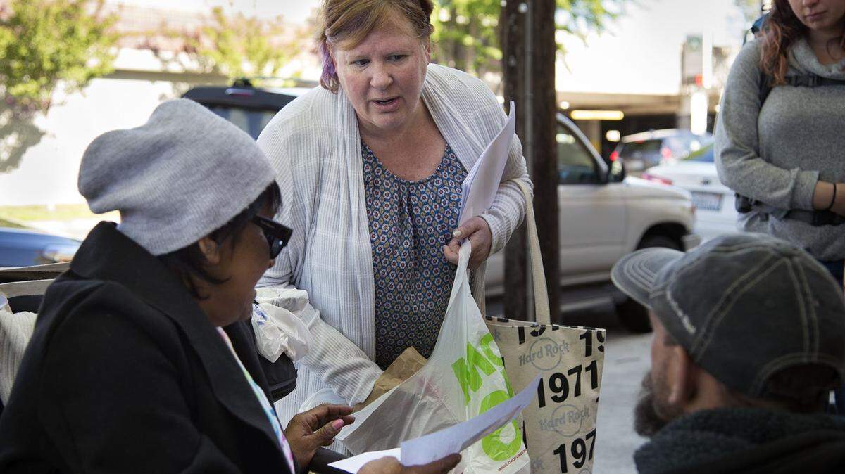 Margaret Wener hands out fliers and food on Friday to a homeless group near 30th and K streets in hopes of getting information regarding her mentally disabled son, Michael Fristoe. After being missing for 12 days, Fristoe was found safe Saturday in the Arden Arcade area.