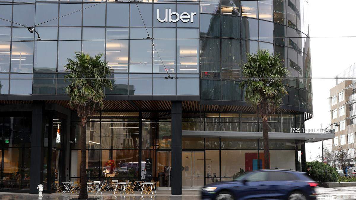 A car drives by Uber headquarters on Feb. 7, 2024 in San Francisco. Ride-hailing company Uber has poured more than $25 million this year on its campaign to place caps on injury attorneys fees.