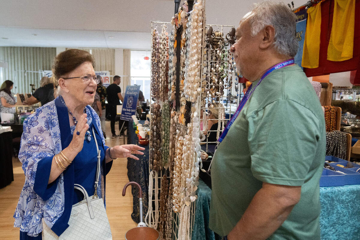 Odette Kaufman, left, speaks with Gil Durano at the Shell La Vie booth during the Gem Faire at the Scottish Rite Masonic Center in Sacramento on Friday, Aug. 2, 2024. Kaufman, who will celebrate her 85th birthday tomorrow, said there is not enough beauty around and that she would buy all of the pieces at the booth if she could.