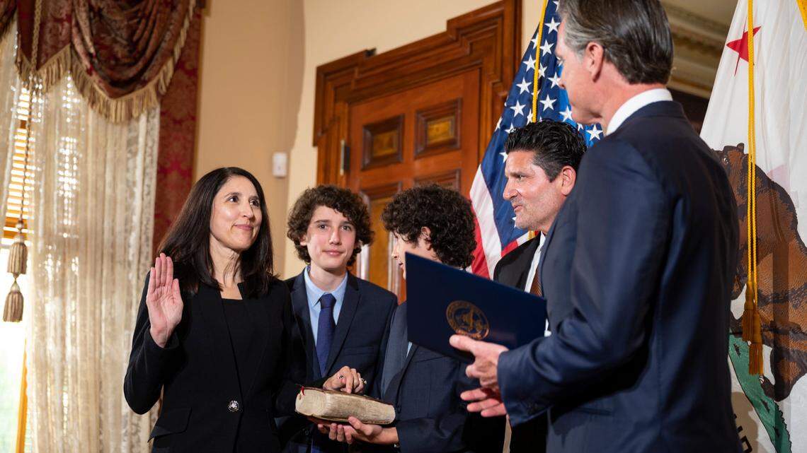 Patricia Guerrero, left, is sworn in to the California Supreme Court in March by Gov. Gavin Newsom at the Stanford Mansion in Sacramento. She is joined by her sons Anthony, left center, and Christopher, holding a family Bible, and her husband Joe Dyson. Newsom nominated Guerrero, the first Latina justice on the state’s highest court, to be the court’s chief justice on Wednesday.
