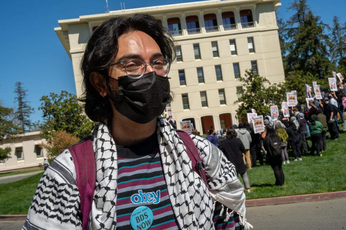 UC Davis law student Shaun Sulur stands in front of Mrak Hall with other students during a walkout on Wednesday. The group was protesting UCD’s suspension of the Law School’s student leadership organization, known as the LSA, after it approved resolved to boycott of Israel for its actions in Gaza.