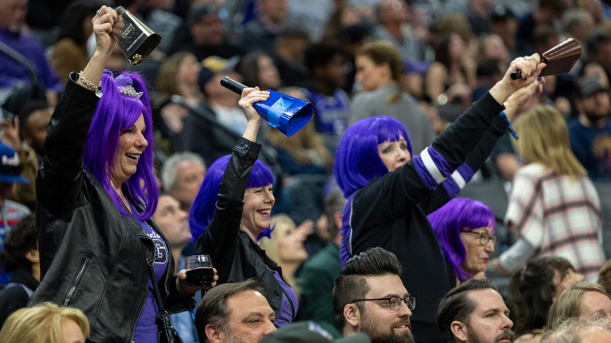 Sacramento Kings fans dressed in purple wigs cheer during a time our in the fourth quarter during a game at Golden 1 Center in Sacramento, Monday, March 27, 2023.