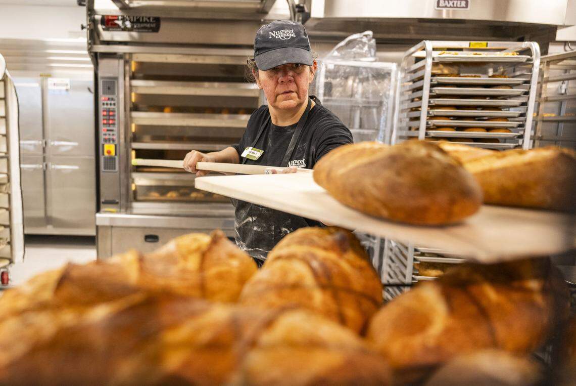 Vanessa Victor, a corporate support lead for Nugget Market, moves fresh baked loaves of bread at the grocery store chain's newest store — located in Rocklin — on Monday, two days before its grand opening.