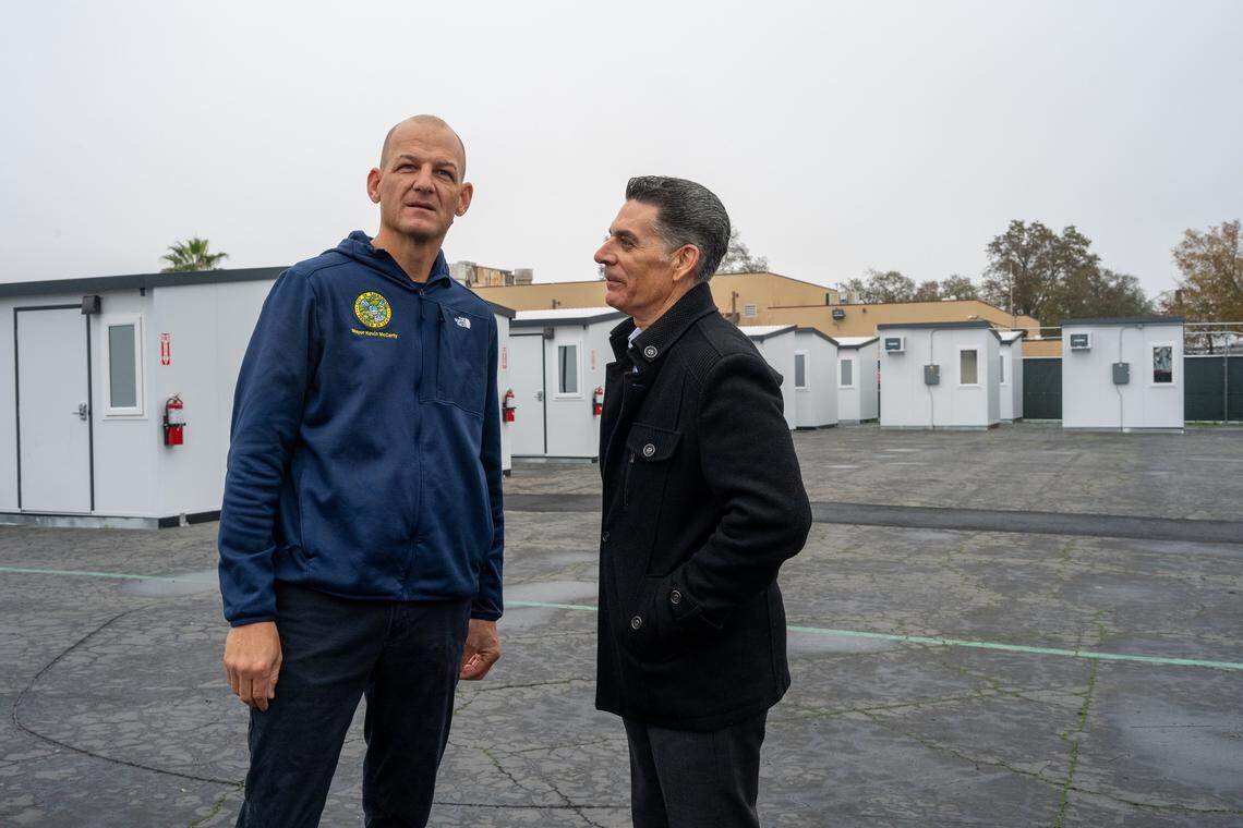 Sacramento Mayor Kevin McCarty, left, and Department of Community Response Director Brian Pedro chat after a press conference on Dec. 18 announcing the addition of 100 new tiny homes available for people experiencing homelessness in Sacramento. The homes, operated by The Gathering Inn, will have individual heating and air-conditioning systems and half of the units will allow pets.