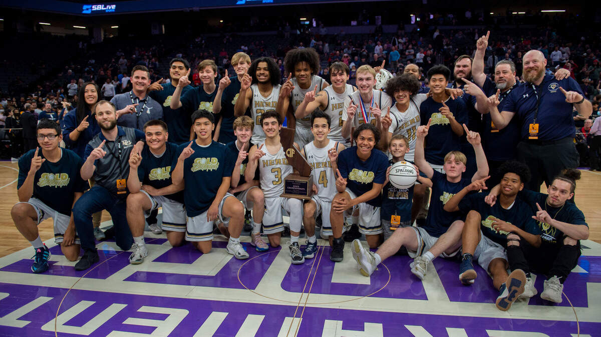 The Elk Grove varsity basketball team pose for photos with the CIF division II state championship trophy after winning against Foothill of Santa Ana on Saturday, March 12, 2022, at Golden 1 Center.