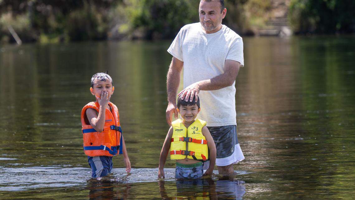 Noorullah Jambi, of Sacramento, enjoys the cold water with his son’s Shahab, 5, and Jason, 3, on the American River at River Bend Park in Carmichael on Thursday. Weather forecast warns of triple digits temperatures starting today.