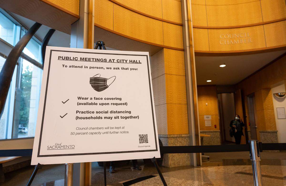COVID-19 pandemic-related rules are posted outside the Sacramento City Council meeting at City Hall on Tuesday, the first meeting back open to public attendance since in-person closures.