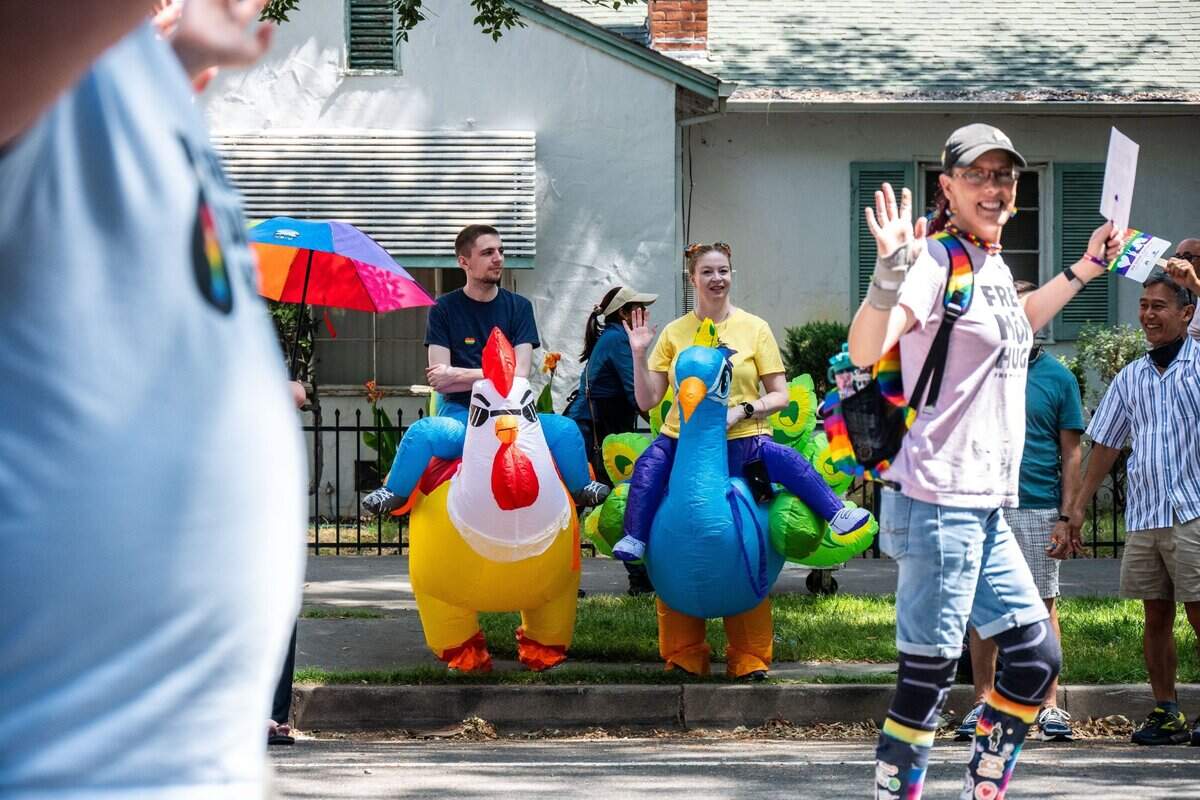 Spectators wearing inflatable costumes wave to parade participants at the Sacramento Pride March on Sunday, June 15, 2025.