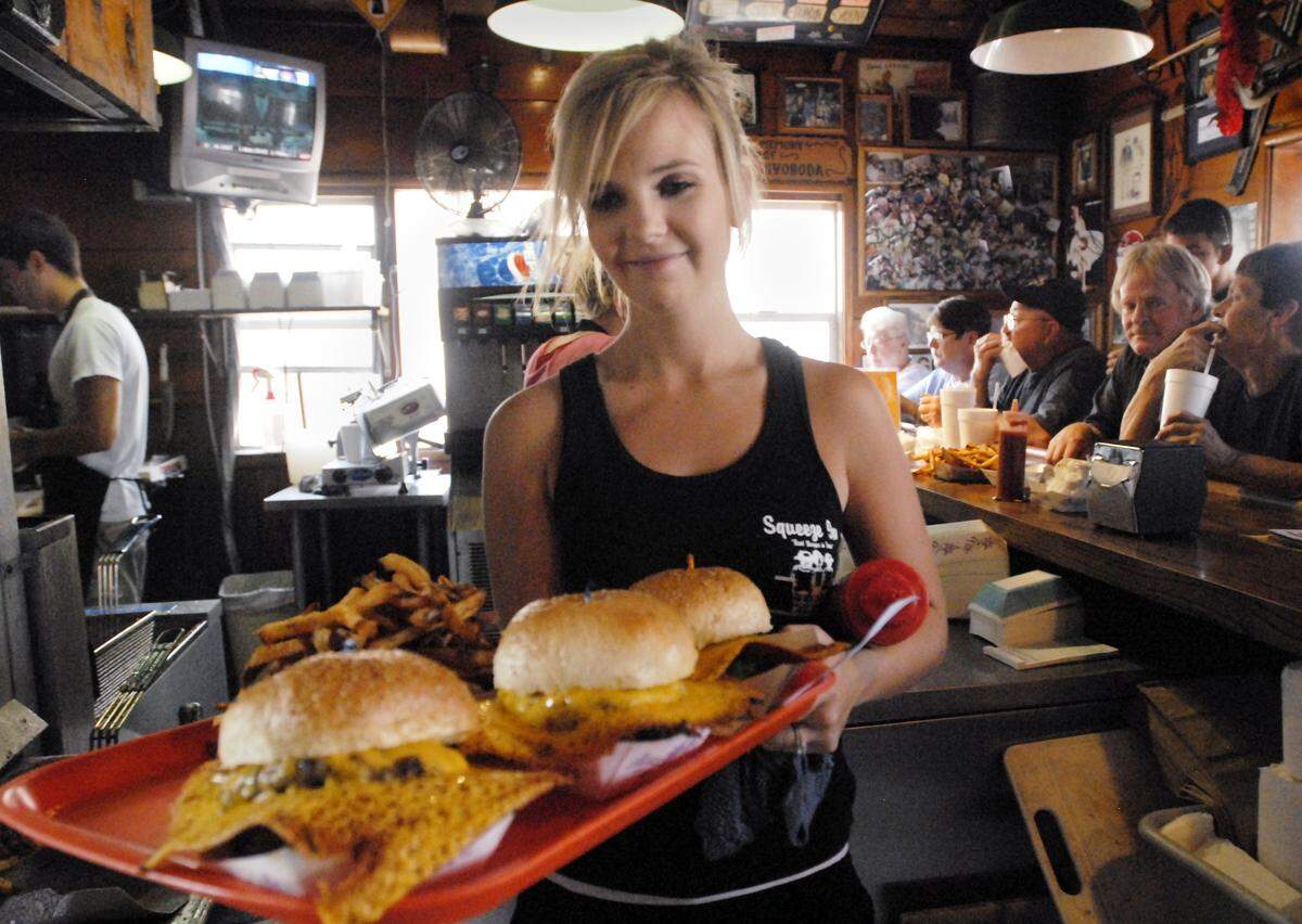 Katie Whitmire serves squeeze burgers to customers at Squeeze Inn on Fruitridge Road in 2007. Helped by a feature on cable's Food Network, the restaurant became the place to go for burgers.