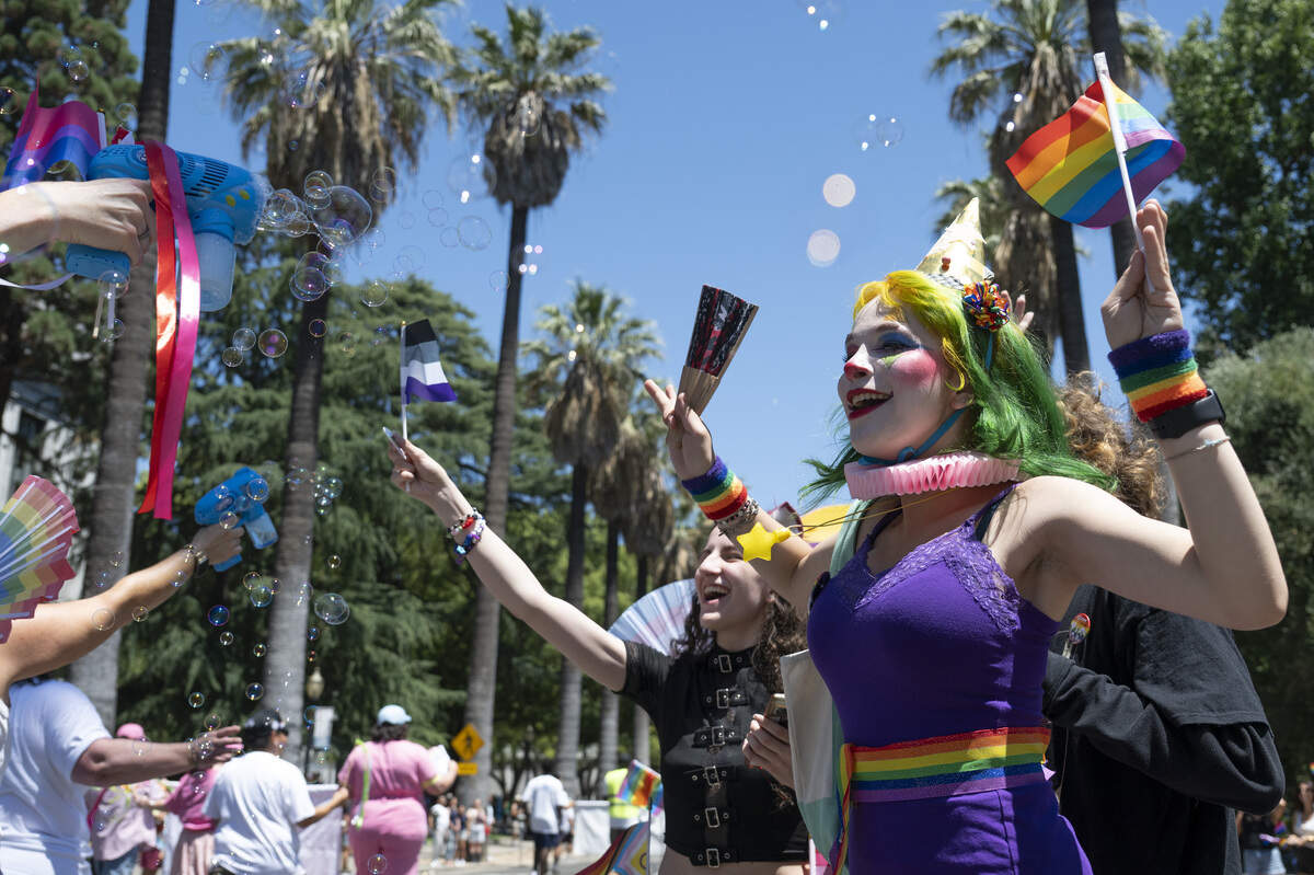 Jordan Ericksen, right, and Zoey Thompson, center, react to bubbles during the Sacramento Pride Parade in Sacramento on Sunday.