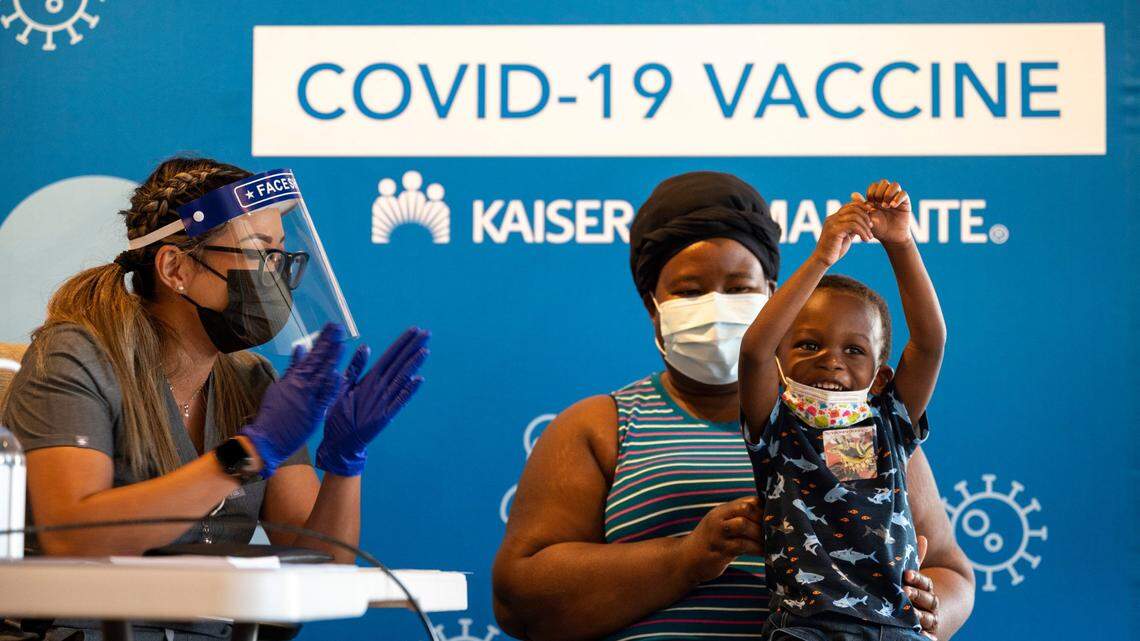 Bryan Yeboah, 3, celebrates after receiving a Moderna COVID-19 vaccination in his thigh from nurse Joanna Marie Pamintuan while being held by his mother, Perpetual Yeboah, at a Kaiser Permanente clinic in Sacramento in 2022. California, Oregon and Washington are moving to issue their own recommendations following federal vaccine rollbacks under U.S. Health and Human Services Secretary Robert F. Kennedy Jr.