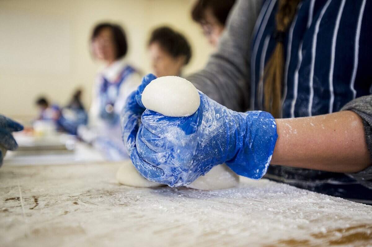 Surya Kishi Grover shapes or “cuts” mochi after it has been pounded during Livingston’s annual Mochitsuki in 2016.