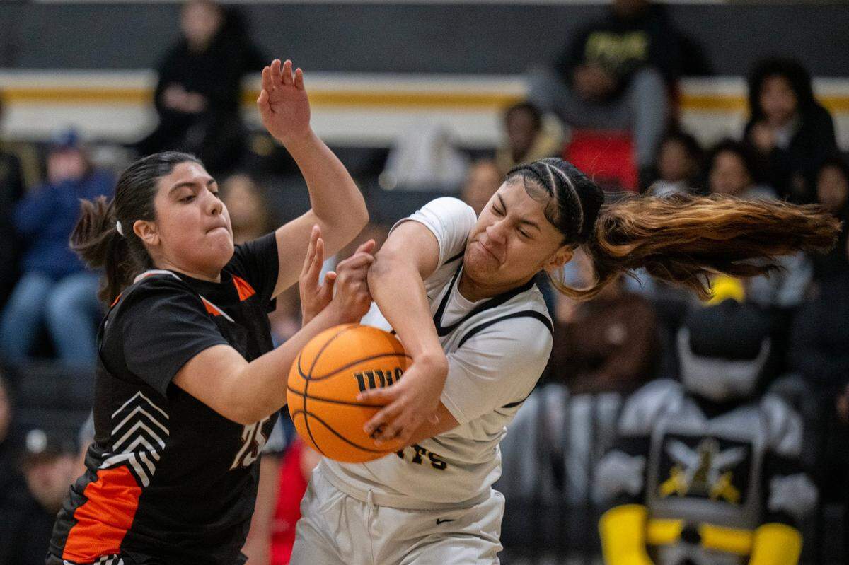 The Marysville Indians’ Lisette Partida (25) and the Rio Linda Knights’ Isabella Hernandez (11) battle for a rebound in the first half of the CIF Northern California Division IV quarterfinals on Thursday.