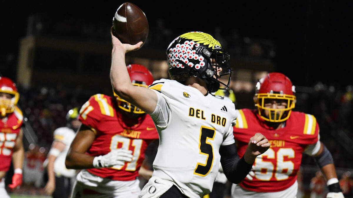 The Del Oro Golden Eagles' Nolen Sauve (5) passes the ball in the first half as the Jesuit Marauders' defense pursues on Friday, Oct. 17, 2025, in Carmichael.