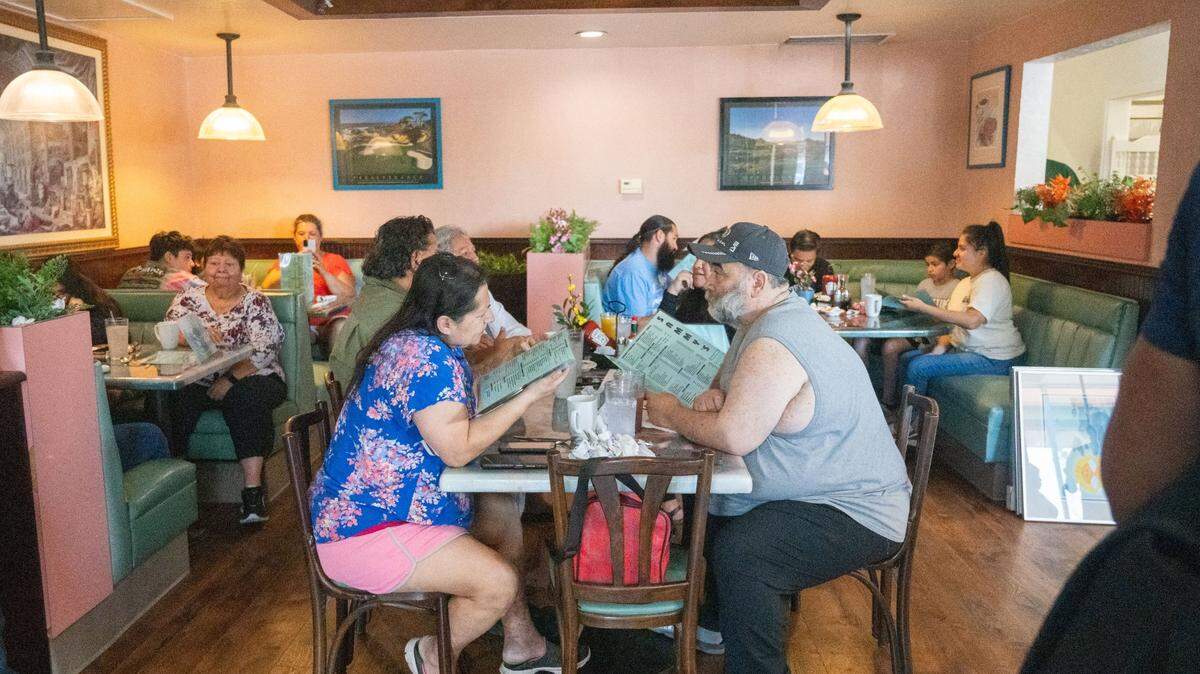 Patrons look through the menu at Sammy’s Restaurant in North Sacramento on Friday, July 19, 2024. The restaurant’s menu includes omelets, pancakes, burgers and sandwiches.