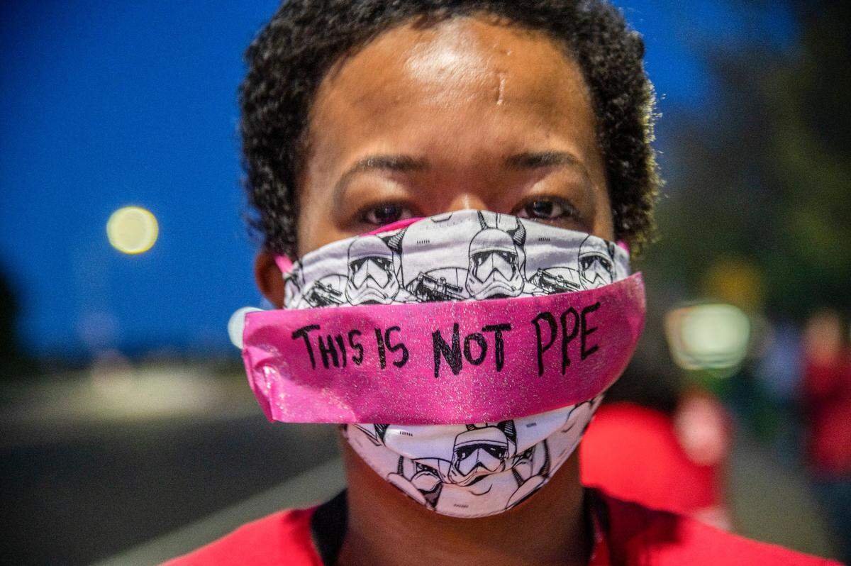 Meredith Piggee, RN, at Sutter Roseville wears a mask highlighting the lack personal protective equipment (PPE), for frontline health care workers during a candlelight vigil on Wednesday, April 1, 2020.