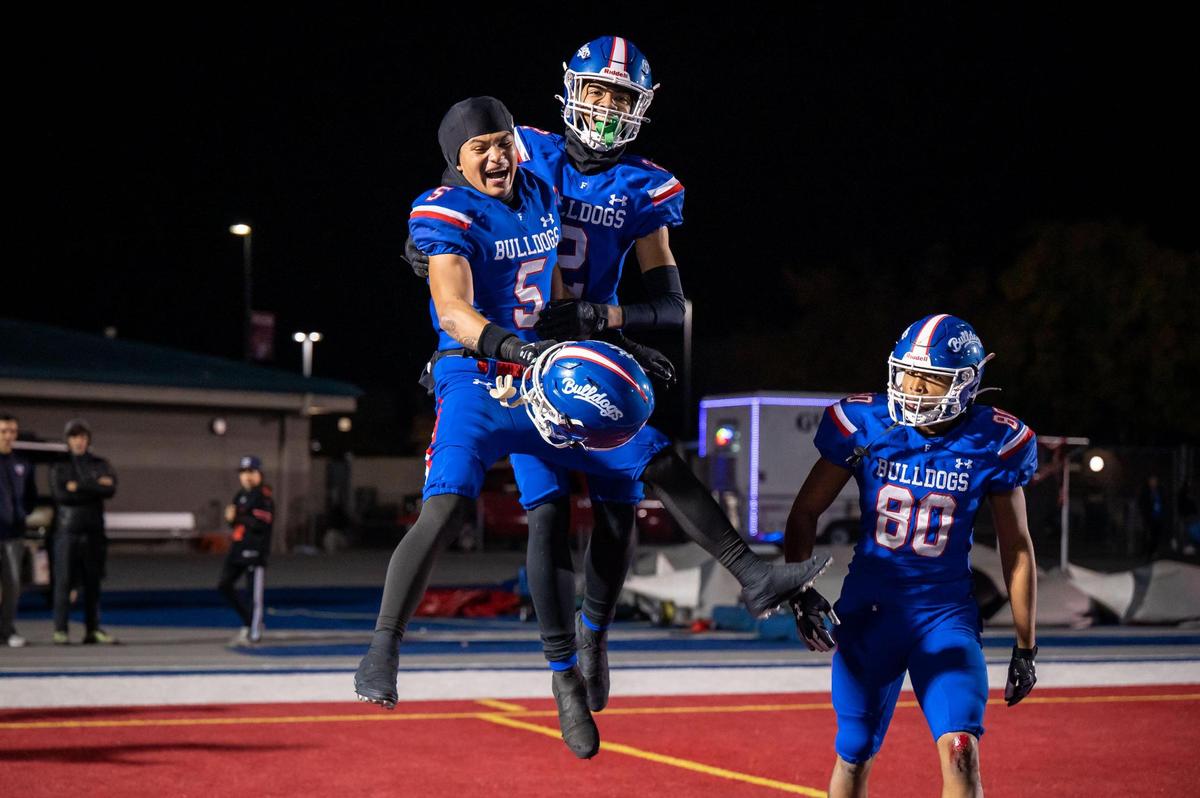 Folsom Bulldog wide receiver Onterrio Smith Jr. (2), center, is congratulated on his touchdown reception by teammates Greco Carrillo (5) and Brian Ray III (80) during the third quarter against Central Catholic of Modesto at the CIF Sac-Joaquin Section Division I high school football semifinal playoff game Friday, Nov. 18, 2022, at Folsom High School. Folsom beat Central Catholic, 62-27.