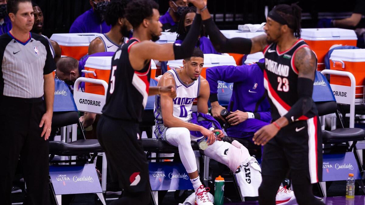 Sacramento Kings guard Tyrese Haliburton (0), center, recovers on the bench as the Portland Trail Blazers celebrate a score during the first half of the NBA game Saturday, Jan. 9, 2021, at Golden 1 Center in Sacramento.