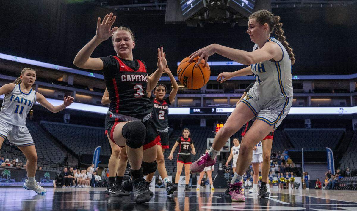 The Sacramento Adventist Capitals’ Gwen Rosich (3) loses the ball to the Faith Christian Lions’ Presley Berry (21) during a CIF Sac-Joaquin Section Division VI girls basketball championship game at Golden 1 Center on Thursday.