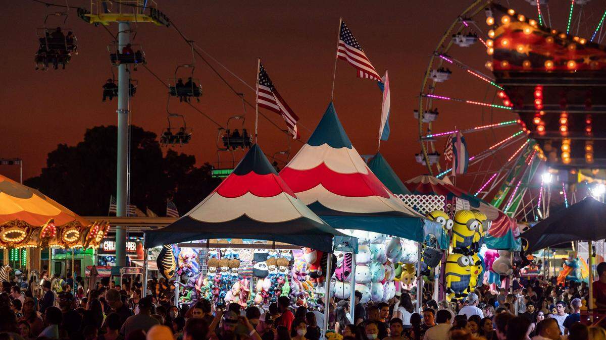 Rides and concessions cast light for visitors on the ground and riding the Sky Ride tram, left, after sunset at Cal Expo during the California State Fair on Tuesday, July 26, 2022, in Sacramento.