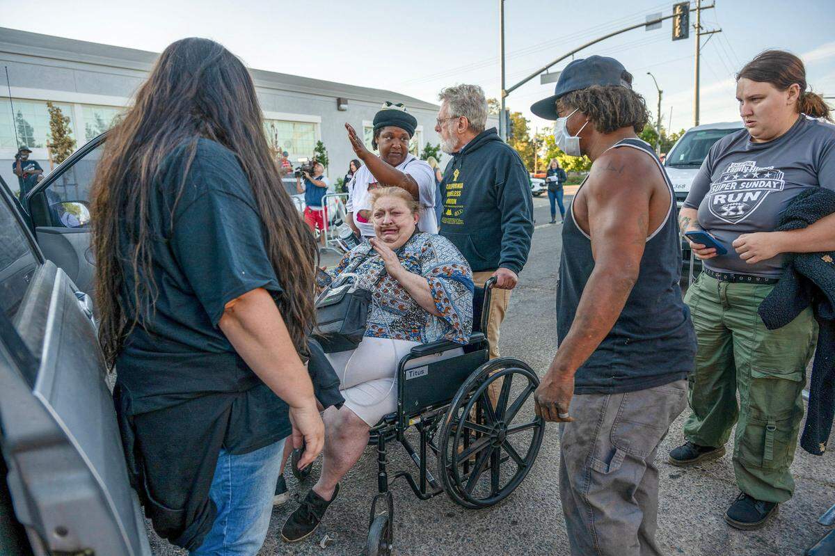 Camp Resolution resident Shonn Adams, 55, is pushed in a wheelchair by attorney Anthony Prince as the City of Sacramento prepares to demolish the camp on Aug. 26. Adams, who uses oxygen to breathe, was crying because she didn’t want to leave her dog or the trailer where she had lived in for the past two years.