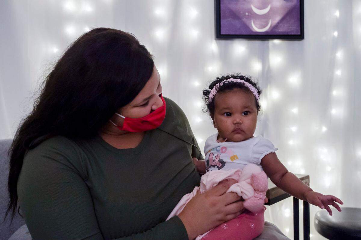 Destinee Campbell, 29, of Sacramento sits on Dec. 9, 2021, with her 4-month-old daughter Marielena Bates in one of the birthing rooms at Welcome Home Midwifery Services in Sacramento. Marielena was born at home under the care of midwife Madeleine Wisner.