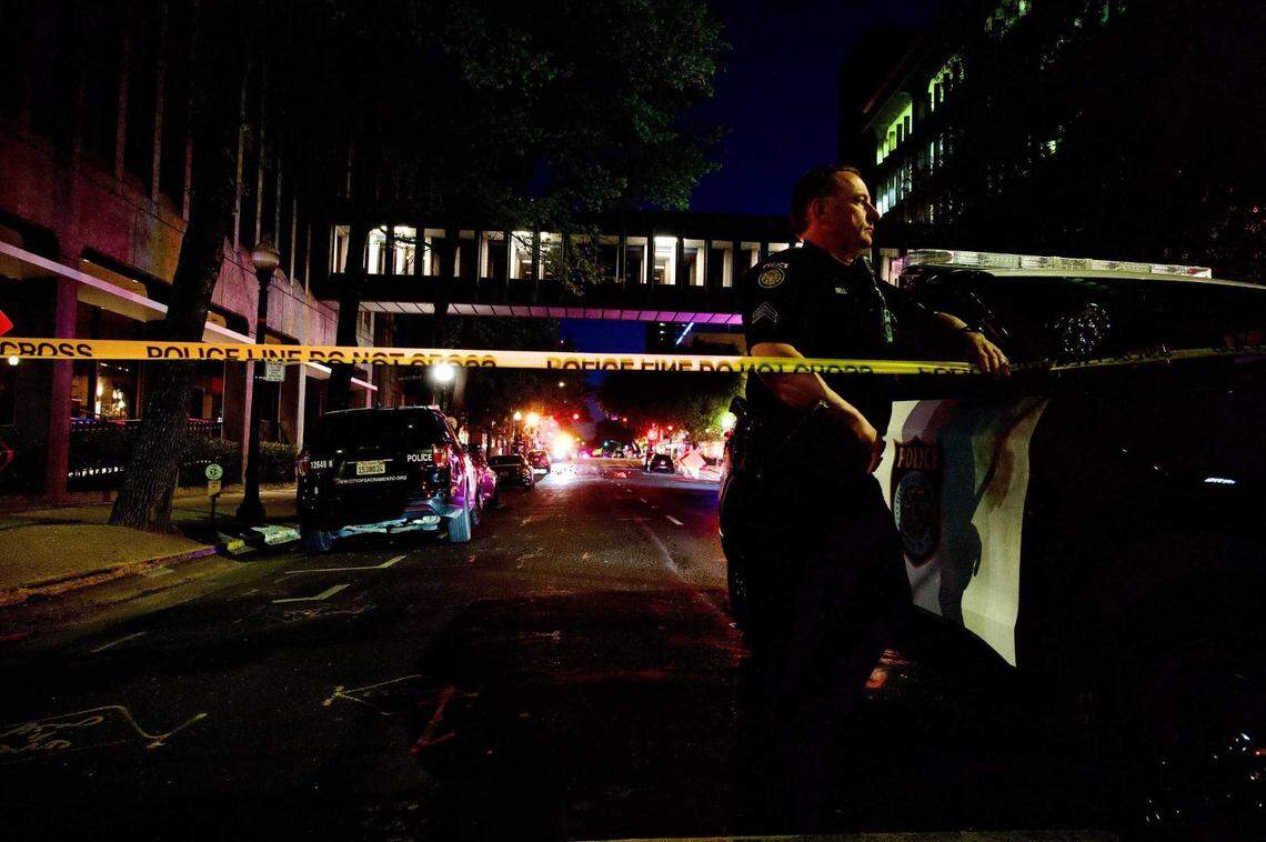 Sacramento Police Department Officer David Bell stands on the scene at 10th and L streets in downtown Sacramento on Sunday, April 3, 2022. Six people were killed and at least nine others have been injured after a shooting in downtown Sacramento.