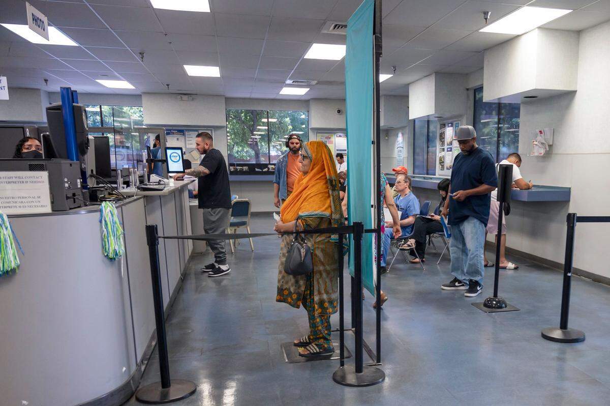 A woman poses for a driver’s license photo at the Broadway DMV in Sacramento on Monday, June 27, 2022.