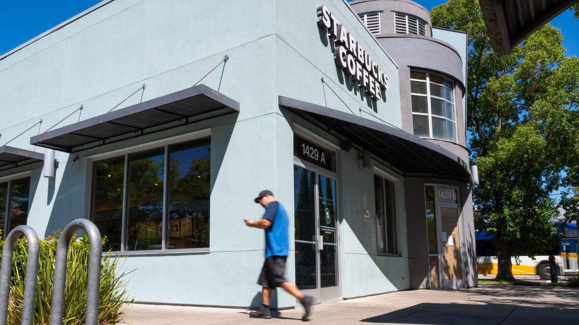 A man walks past a Starbucks coffee shop on his way back to his car after reading a sign on the door of the recently closed Jamba Juice shop at 1429B Broadway in Sacramento in July. Starbucks announced the location is closing.