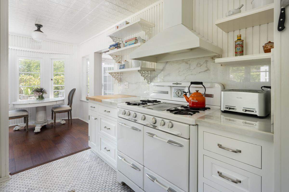 The main residence is timeless, boasting a beautifully updated kitchen and primary bathroom adorned with original details, stained glass, and elegant finishes.