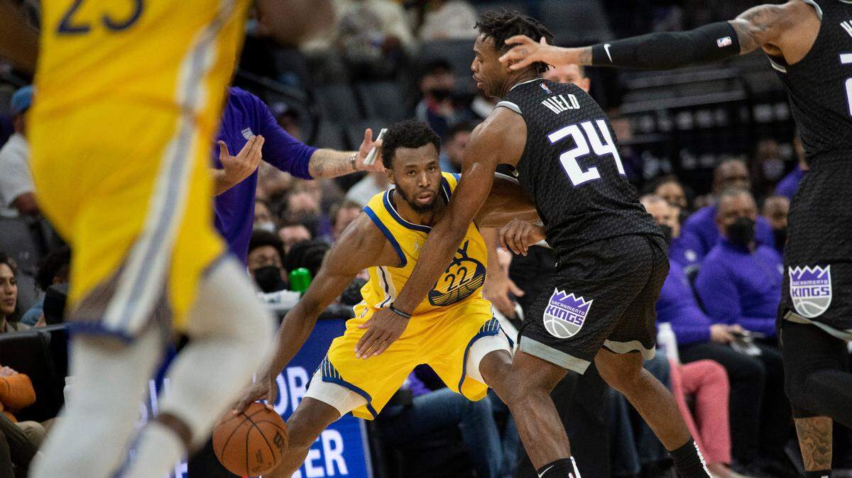 Sacramento Kings guard Buddy Hield (24) guards Golden State Warriors forward Andrew Wiggins (22) during the second half of an NBA basketball game in Sacramento, Calif., Sunday, Oct. 24, 2021. The Warriors won 119-107. (AP Photo/Randall Benton)