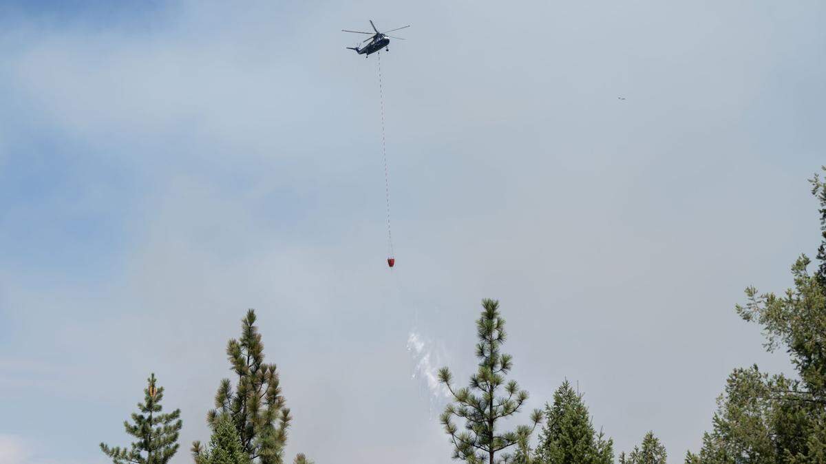 A helicopter drops water as Cal Fire crews work the Crozier Fire in El Dorado County on Wednesday, Aug. 7, 2024.