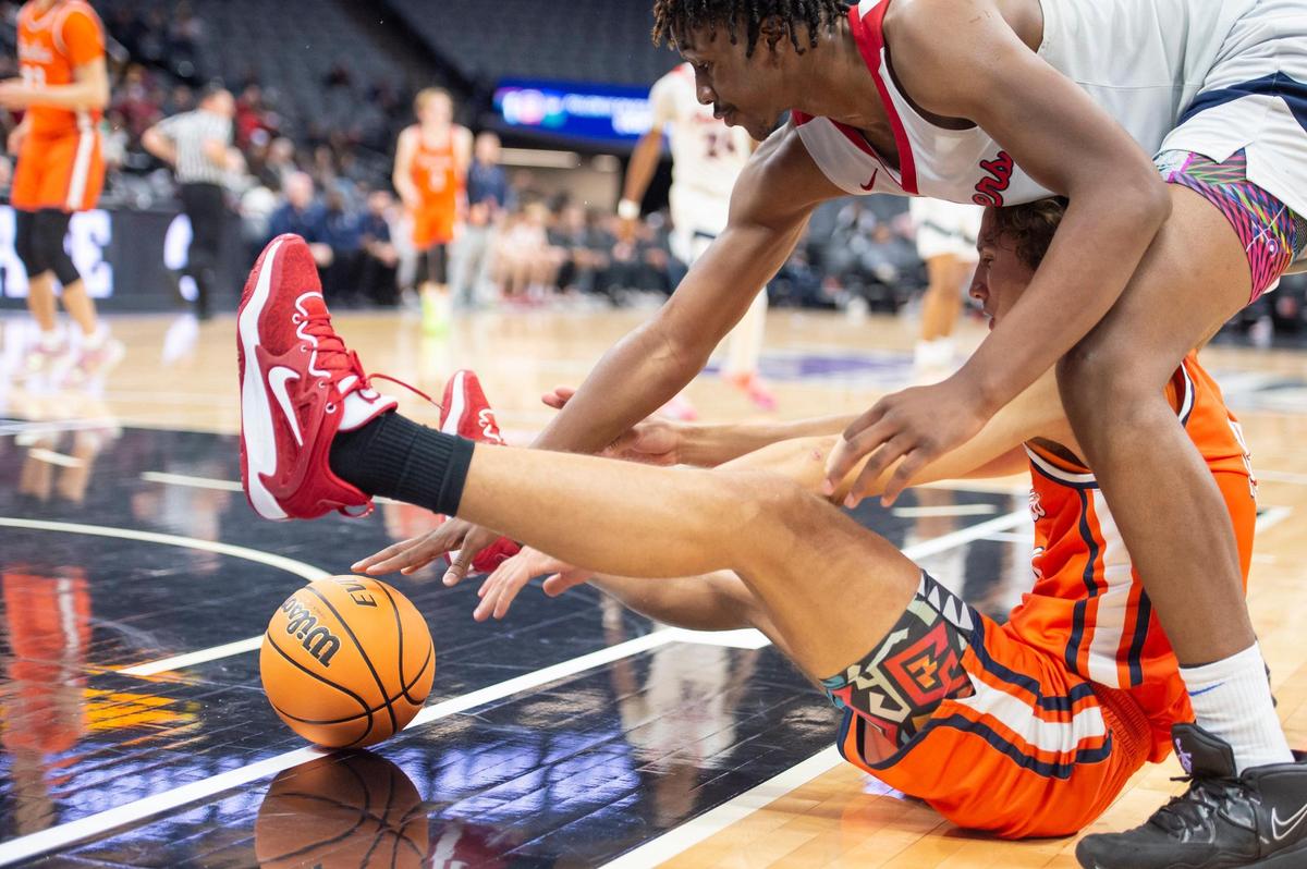 Pacifica Christian Tritons Logan Stewart (11) and San Joaquin Memorial forward Mike Davis Jr. (5) battle for possession of the ball in the first half in the CIF State Division II Boys Basketball Championships on Saturday, March 11, 2023, at Golden 1 Center in Sacramento.
