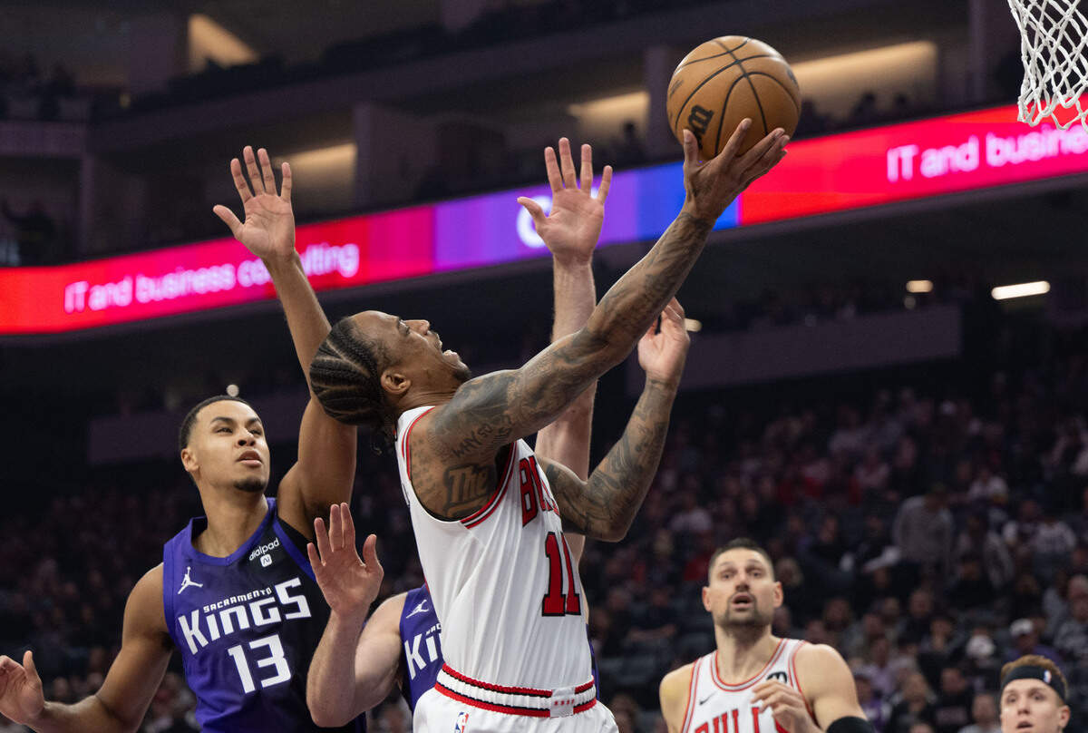 Chicago Bulls forward DeMar DeRozan (11) drives past Sacramento Kings center Domantas Sabonis (10) and forward Keegan Murray (13) during an NBA game March 4 at Golden 1 Center.