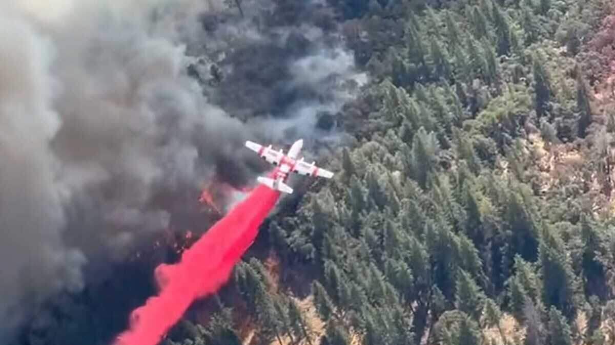 A Cal Fire aircraft drops retardant on the head of the Ponderosa Fire on Sunday in eastern Yuba County. The fire has torched close to 90 acres and was 30% contained as of Monday.