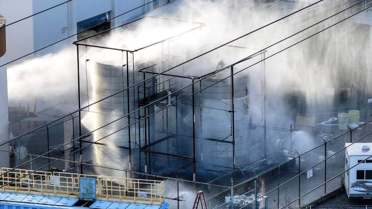 A pressurized tank filled with methyl methacrylate is sprayed with water at GKN Aerospace in Garden Grove on Saturday.