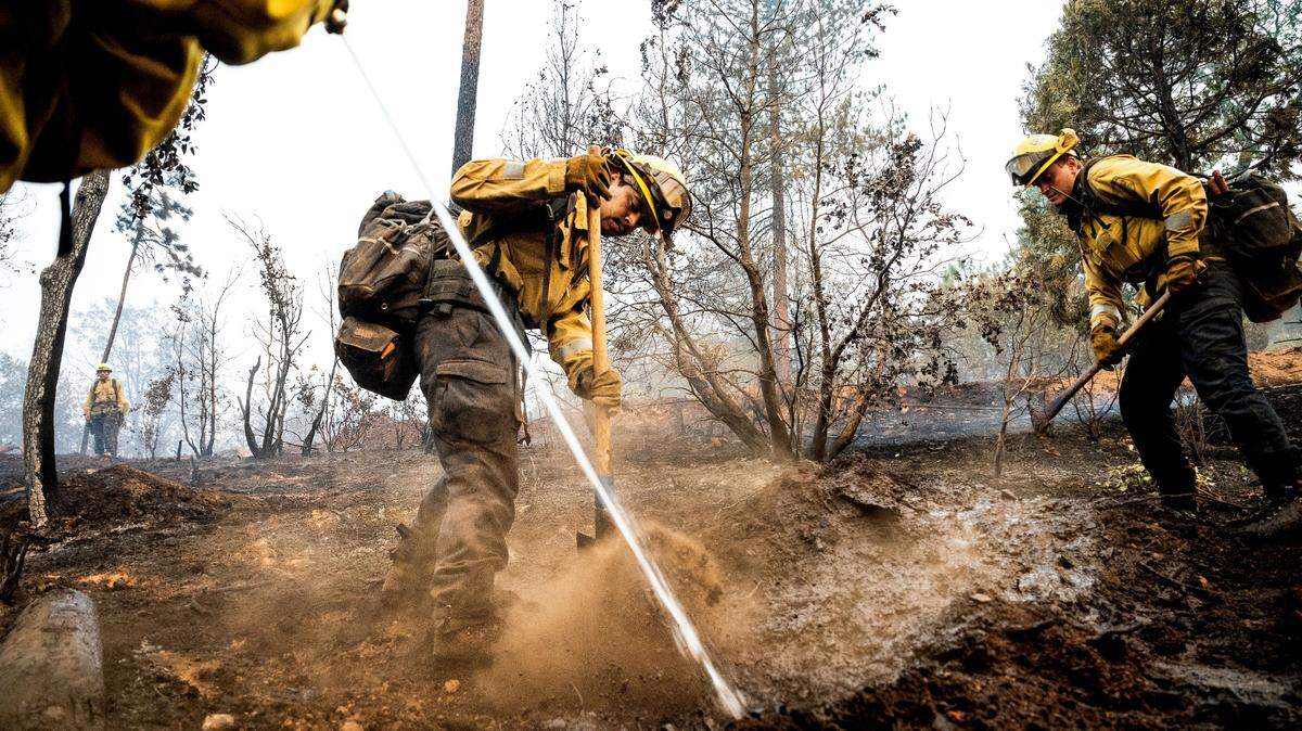 Firefighter Sergio Porras mops up hot spots while battling the Oak Fire in the Jerseydale community of Mariposa County, Calif., on Monday, July 25, 2022. He is part of Task Force Rattlesnake, a program comprised of Cal Fire and California National Guard firefighters. (AP Photo/Noah Berger)