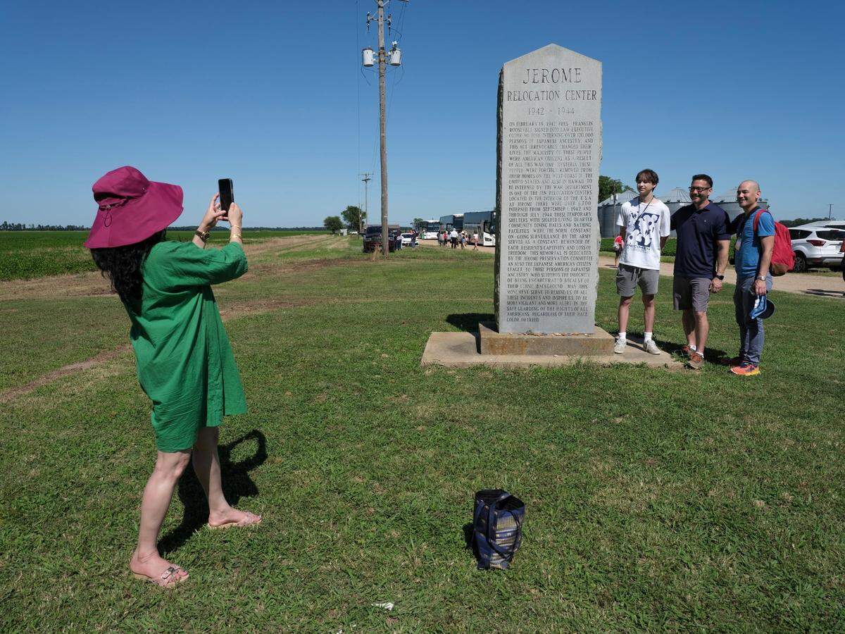 Juhu Thukra takes a photograph of Jackson, Scott and Jeffrey Yamaguchi on their first visit to the Jerome incarceration camp on June 6 in Arkansas. Their family members were incarcerated at the nearby Rowher incarceration camp during World War II.