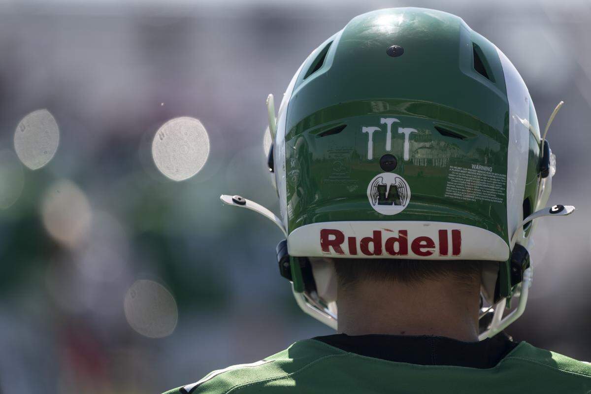 Dixon varsity football athletes wear “IA” stickers on their helmets in honor of junior varsity player Isaac Arredondo during a game between Dixon and Casa Roble in Dixon on Saturday. Arredondo died on Oct. 10.