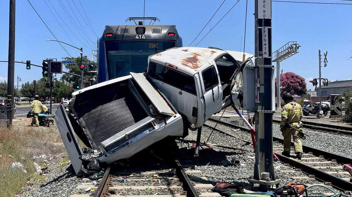 A Chevrolet Silverado pickup truck is pinned against the front of a Sacramento Regional Transit light rail train after a crash in Rancho Cordova on Friday, July 3, 2026. Firefighters extricated the critically injured driver from the wreckage.