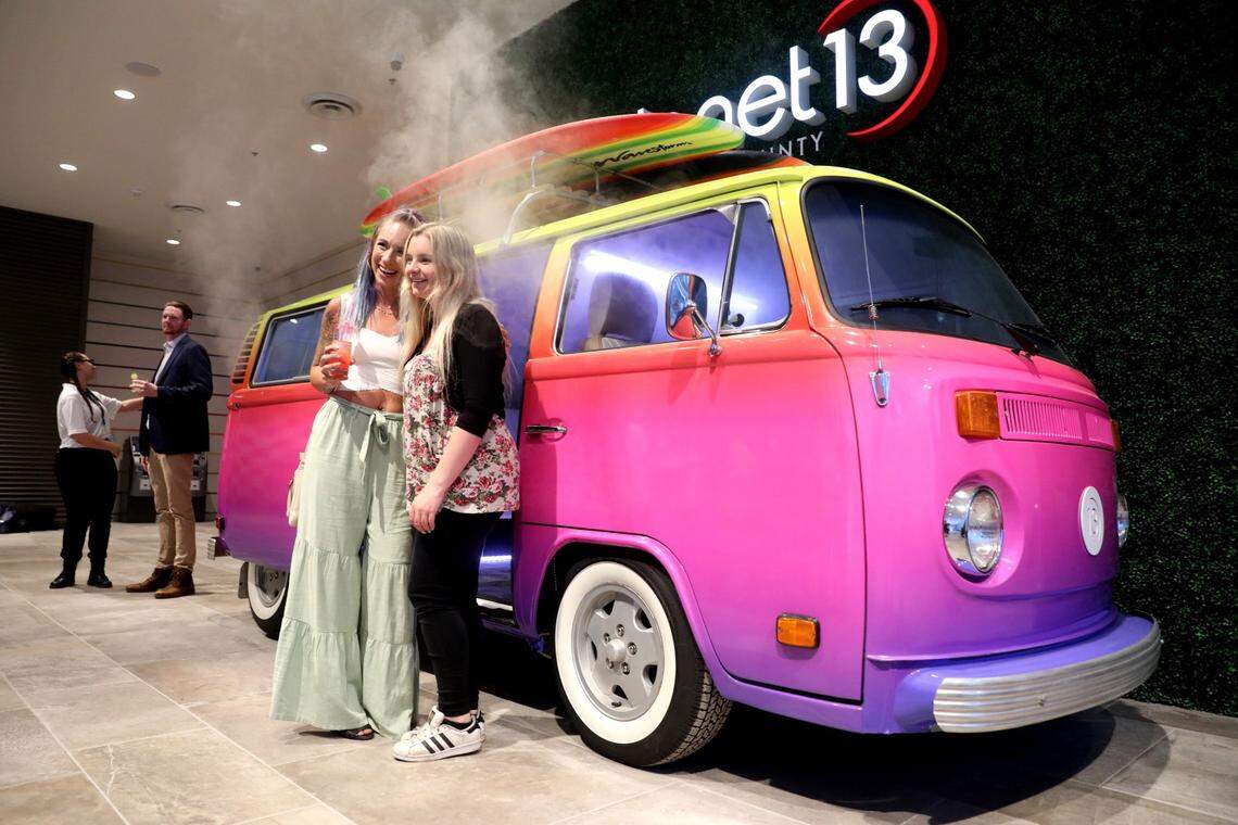 Two friends take a photo of a restored Volkswagen bus that emits smoke at the push of a button at Planet 13, an Orange County dispensary billed as the second-largest cannabis superstore in the world.