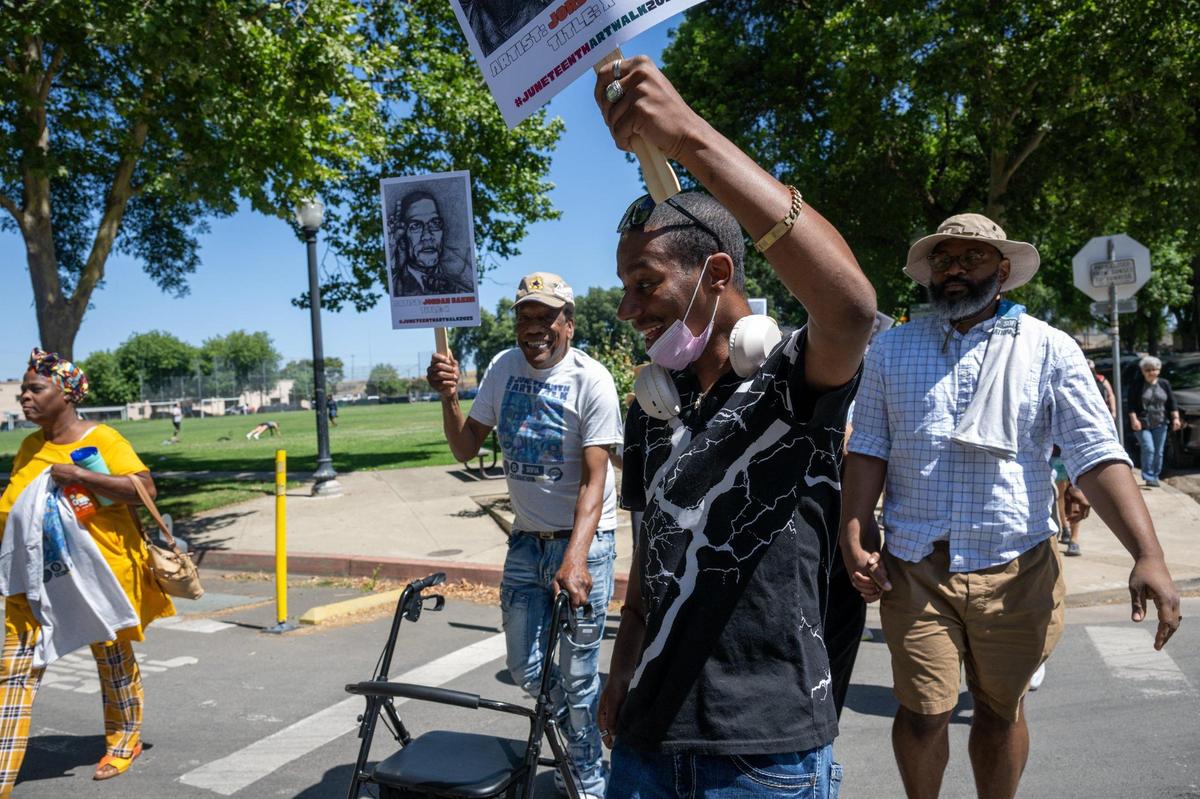 Joseph Trotter, left, using his walker, parades down the street to the music of the New Orleans-style Element Brass Band to the Capital Stage during the second annual Juneteenth Art Walk on Thursday in Sacramento.