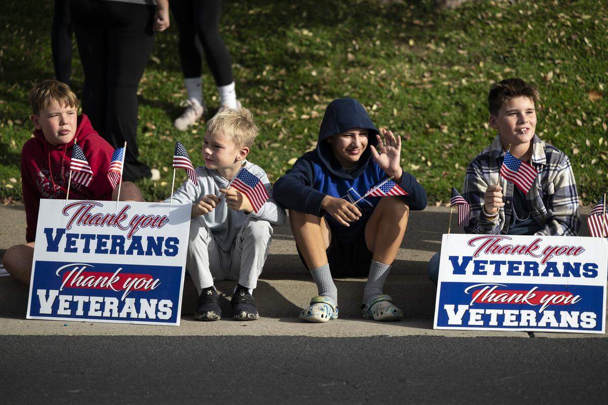 From left, Declan Marsh, Lincoln Marsh, Lucas Chesnik and Maxwell Marsh watch a Veterans Day parade in Folsom on Tuesday, Nov. 11, 2025.