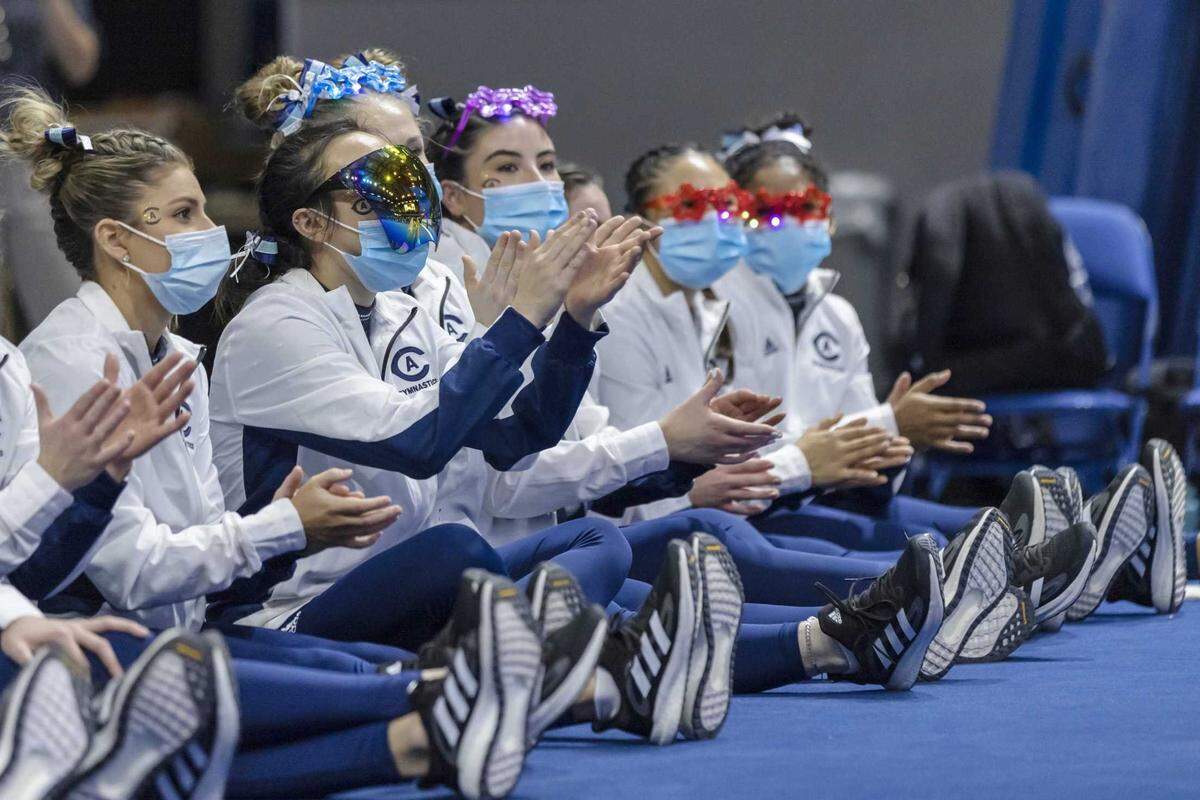 UC Davis gymnasts wear masks during a meet against Sacramento State in 2022. The COVID state of emergency is over, but the mask debate is not. 