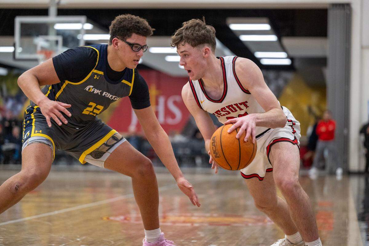 The Jesuit Marauders’ Asher Schroeder (22) dribbles as the Oak Ridge Trojans’ Kaleb Edwards (23) defends on Jan. 17 in Carmichael. 