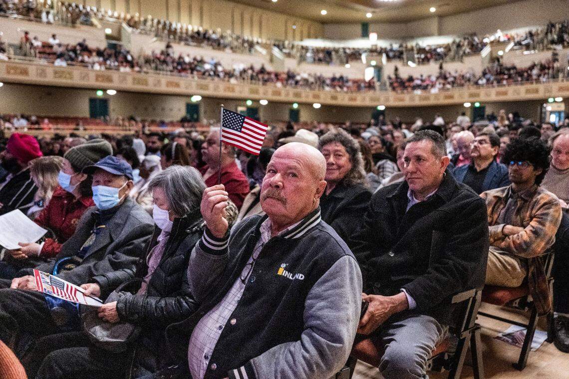 Loyalton resident David Reddecop, originally from Belize, waves an American flag as he and more than 800 people took the oath to become U.S. citizens on Wednesday at the Memorial Auditorium in Sacramento.