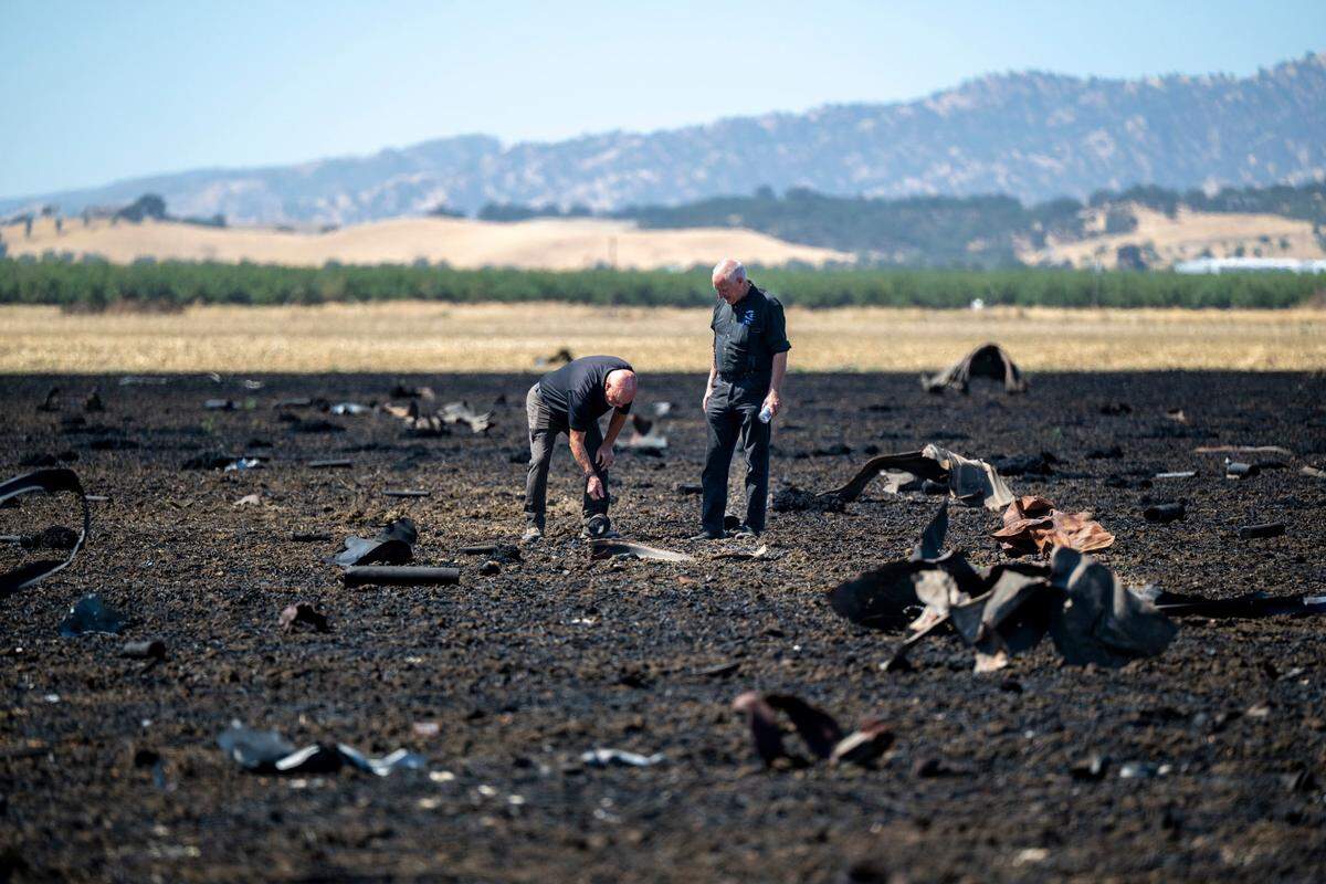 Fire investigators examine debris from the Devastating Pyrotechnics explosion in a nearby field in Esparto on Monday, July 21, 2025. The facility exploded on July 1, 2025.