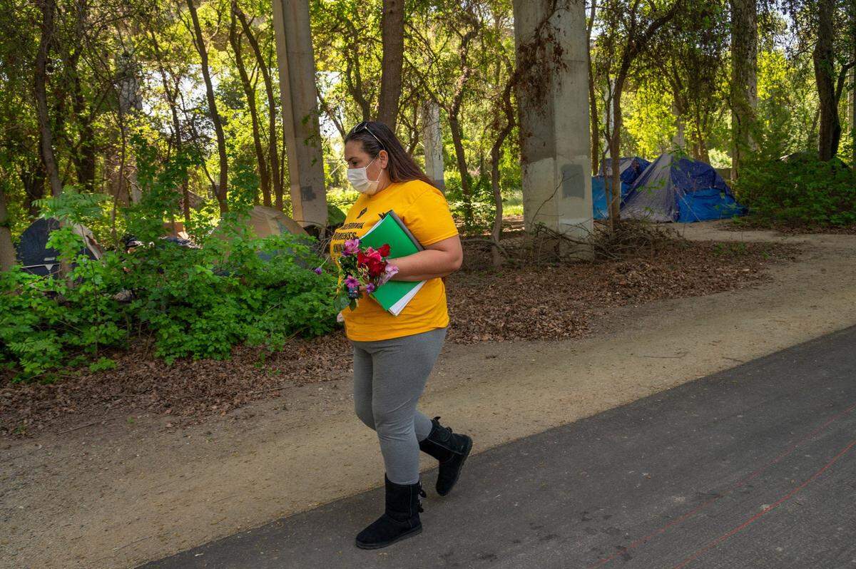 Crystal Sanchez, president of the Sacramento Homeless Union, searches the American River bike trail in April with flowers from her garden to memorialize Kathy Lynn Robbins, who was found dead April 10 near Railroad Drive and Del Paso Blvd. “I want the community to take a second and think about this – just think about a woman out here in the woods being violently assaulted, screaming, and there is nobody to help, nobody to call 911, no way for her to escape,” said Sanchez. “Imagine having to die like that. It gives me chills and it happens more than people know.”