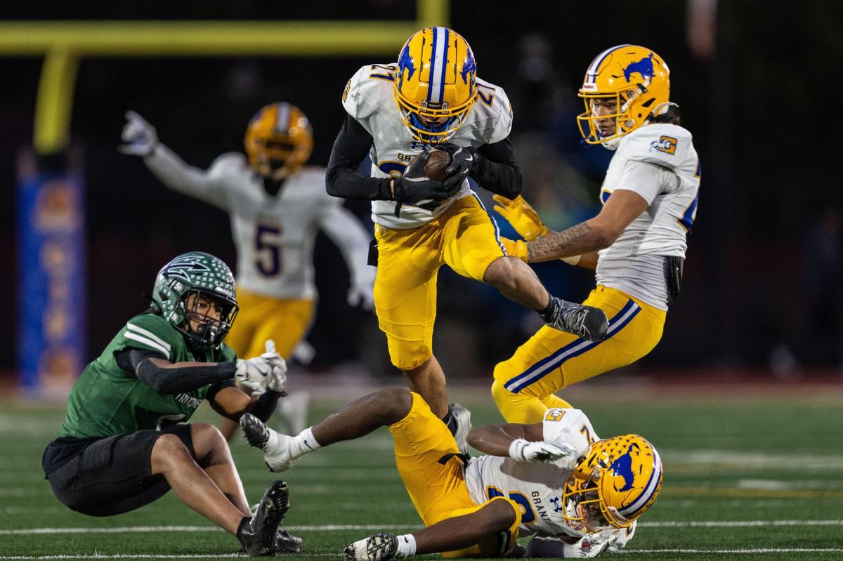 The Grant Pacers’ Gary Tia (21) leaps over teammate Koby Shabazz (2) after he intercepts a pass intended for the Pacifica Tritons’ Isaiah Dillon (1) during the CIF State Division 2-AA championship at Saddleback College in Mission Viejo on Friday. Tia returned the ball for a pick six.